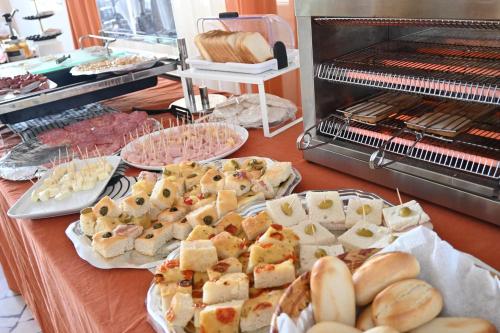 a table topped with plates of bread and pastries at Hotel B&B Ardea Rimini in Rimini