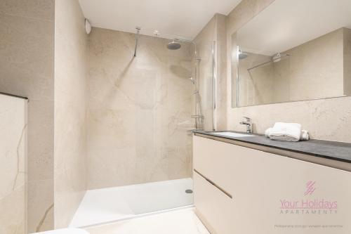 Un baño con ducha, lavabo y espejo. en Your Holidays Infinity A227, en Międzyzdroje