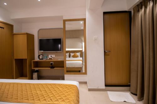 a hotel room with a bed and a television at Hotel Malad Inn opposite Malad Railway Station in Mumbai