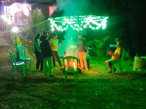 a group of people standing around a fire at night at Misty valley Private Pool Villa Munnar in Anachal