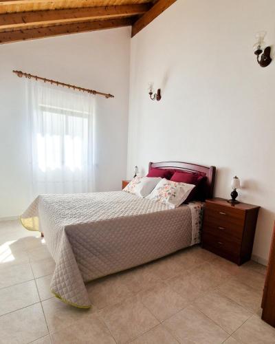 a bedroom with a large bed and a window at Rural House in Boavista dos Pinheiros