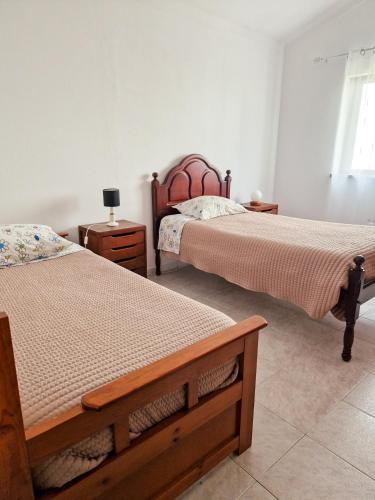 a bedroom with two beds and two night stands at Rural House in Boavista dos Pinheiros