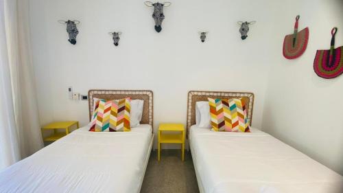 ラス・テレナスにあるPrivate Pool Villa With Parkingの壁に頭蓋骨が飾られた部屋にベッドが2つある