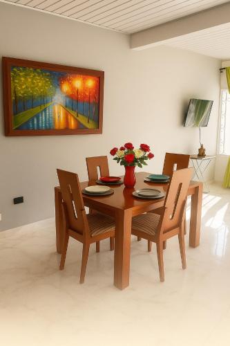 a dining room table and chairs with a painting on the wall at Apartamento central Wiky House in Guaduas