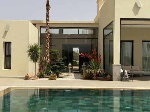 a house with a swimming pool in front of a house at Luxury Villa Pool with Atlas View in Moussiha