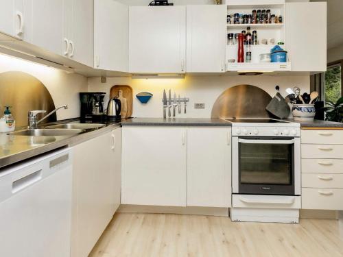 a kitchen with white cabinets and a sink at Beachside Serenity-By Traum in Løkken