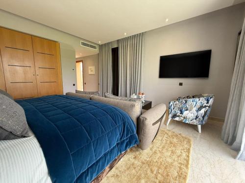 a bedroom with a large blue bed and a chair at Luxury Villa Pool with Atlas View in Moussiha