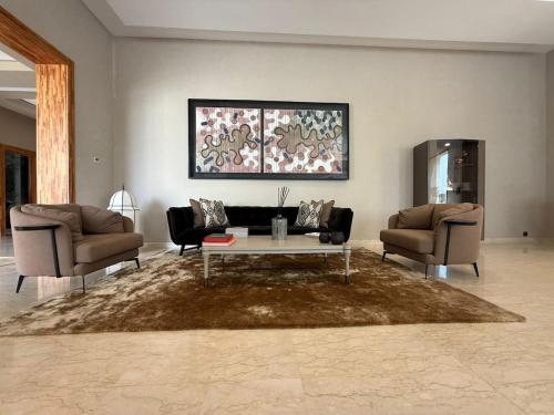 a living room with two couches and a coffee table at Luxury Villa Pool with Atlas View in Moussiha