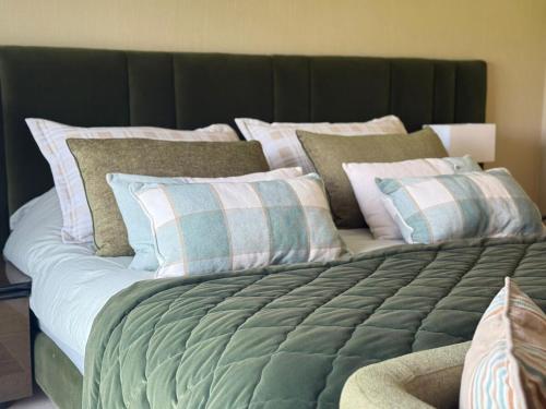 a large bed with many pillows on top of it at Luxury Villa Pool with Atlas View in Moussiha