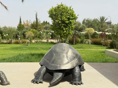a statue of a turtle sitting on a sidewalk at Luxury Villa Pool with Atlas View in Moussiha