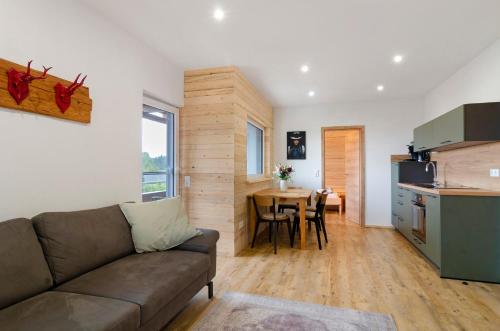 a living room with a couch and a kitchen with a table at Pension Ferienwohnung Baarblick in Donaueschingen