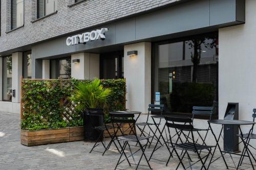 a group of tables and chairs in front of a store at Citybox Antwerp in Antwerp