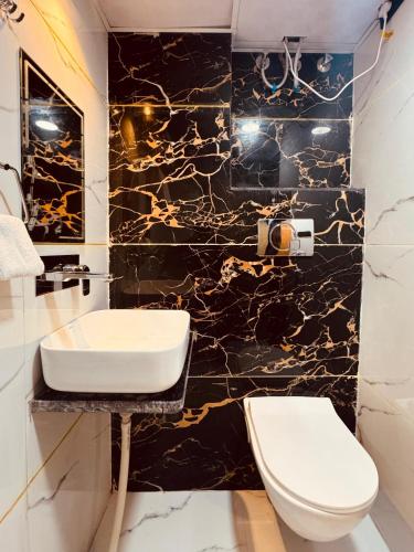 a bathroom with a white toilet and a black marble wall at The kanak valley Hotel in Jaipur