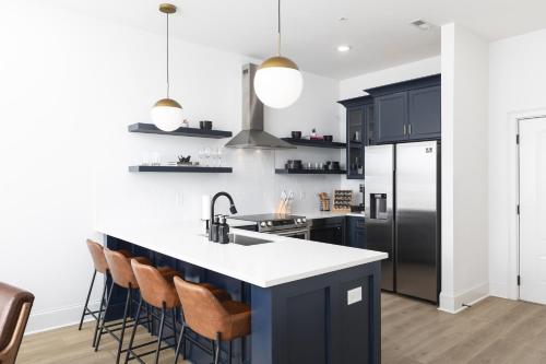 a kitchen with black cabinets and white countertops at Hip New Condo near Broadway and Trendy East Nash with 5 Beds in Nashville