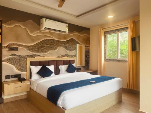 - une chambre avec un grand lit et une fresque murale dans l'établissement The kanak valley Hotel, à Jaipur