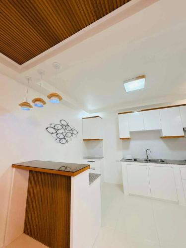 eine Küche mit weißen Schränken und einer Arbeitsplatte in der Unterkunft Elegant 3 Bedroom House near Airport in Sampong