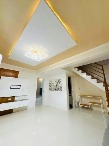 ein großer weißer Raum mit einer Decke mit einer Treppe in der Unterkunft Elegant 3 Bedroom House near Airport in Sampong