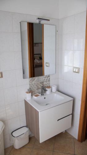 a white bathroom with a sink and a mirror at Casa Talìa in Centuripe