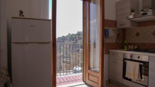 a kitchen with a sliding glass door leading to a balcony at Casa Talìa in Centuripe