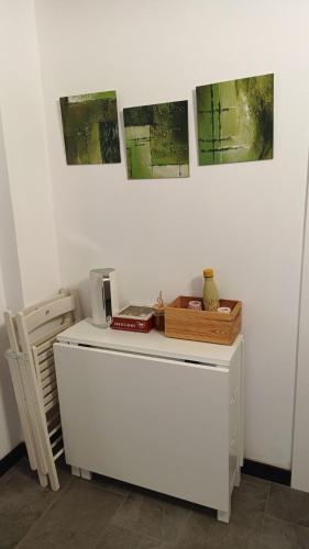a white cabinet with three pictures on the wall at LA TANA DELLA VOLPETTA - Bed & Breakfast in Stella