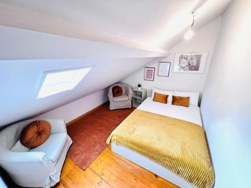 a attic bedroom with a bed and a chair at City centre of Lisbon, ideal for tourists in Lisbon