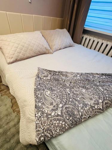 a bed with a comforter and a pillow on it at SMART flat - Ranna 49 in Sillamäe