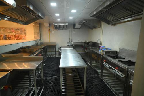 a large kitchen with several tables in a kitchen at Quality Inn Rama, Ayodhya in Ayodhya