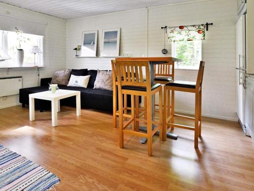 a living room with a couch and a table and chairs at 4 person holiday home in Gränna in Gränna