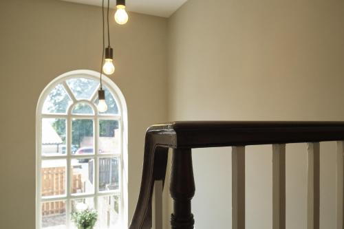 Zimmer mit einer Treppe und einem Fenster mit Licht in der Unterkunft 1 Manor Cottage, Ainderby Steeple, DL7 9PX in Northallerton