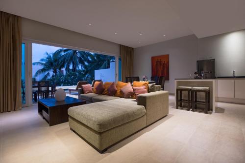 a living room with a couch and a table at Tropical Serenity - Elegant 1 Bedroom with Pool in Ban Saiyuan (1)