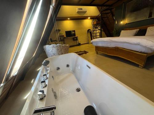 a bath tub in a room with a bed at Gumaan Resort in Skardu
