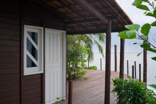 a house on the beach with a door and a porch at Vila Maré in Itacaré