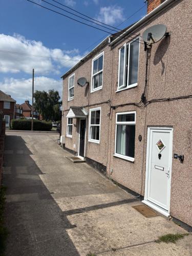 a brick building with a white door on a street at Little Manor in Chesterfield