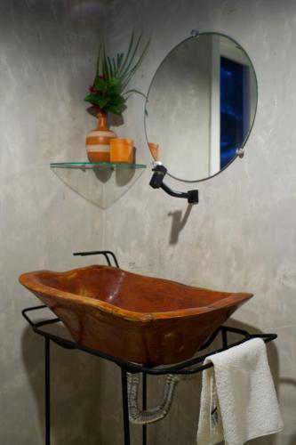 a bathroom with a wooden sink and a mirror at Vila Maré, vista panoramica do mar in Itacaré