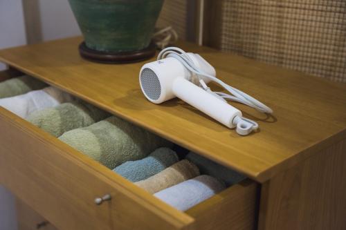 a wooden drawer with a speaker on top of it at Nitichai place, Cozy 3-Storey Sukhumvit Stay in Bangkok