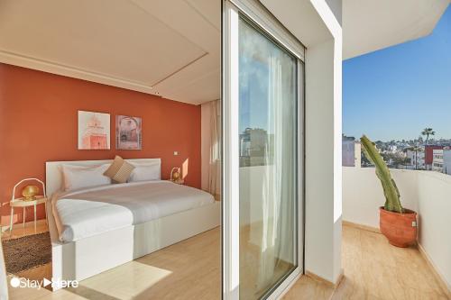 a bedroom with a bed and a large window at Stayhere Rabat - Hassan - Authentic Residence in Rabat