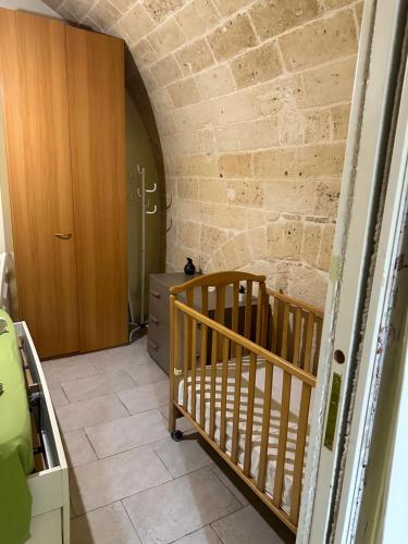 a room with a crib and a brick wall at futura home centro storico 5 minuti da Bari in Modugno