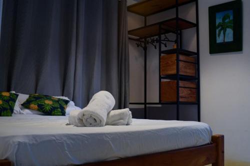 a bedroom with a bed with towels on it at Vila Maré in Itacaré