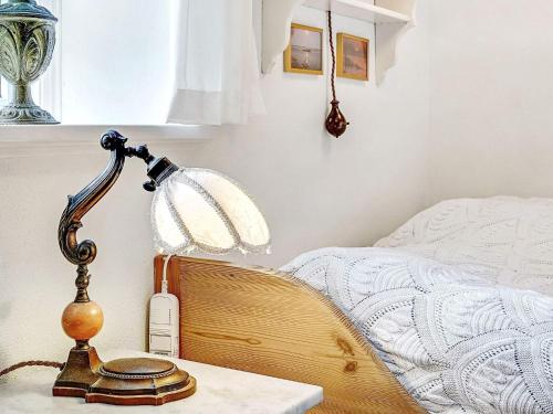 a lamp sitting on a table next to a bed at 4 person holiday home in Tønder in Tønder