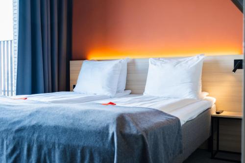 a hotel room with a bed with white sheets and pillows at Citybox Antwerp in Antwerp