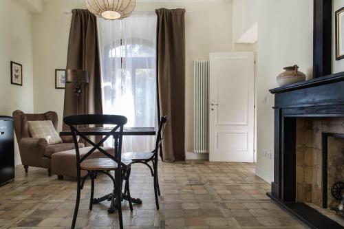 a living room with a chair and a table and a fireplace at FEDERICO Bed and Wellness in Capestrano
