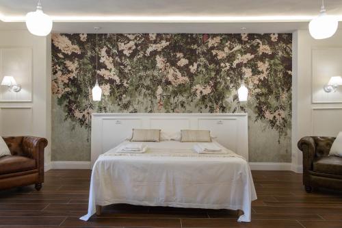 a bedroom with a white bed with a floral wallpaper at FEDERICO Bed and Wellness in Capestrano