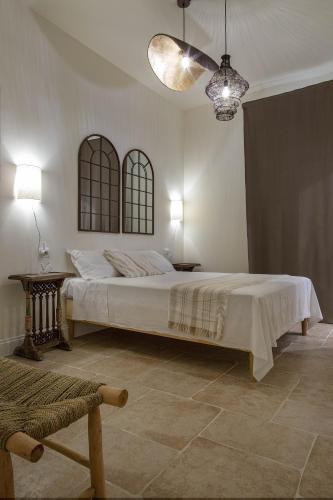 a bedroom with a large bed and two windows at FEDERICO Bed and Wellness in Capestrano
