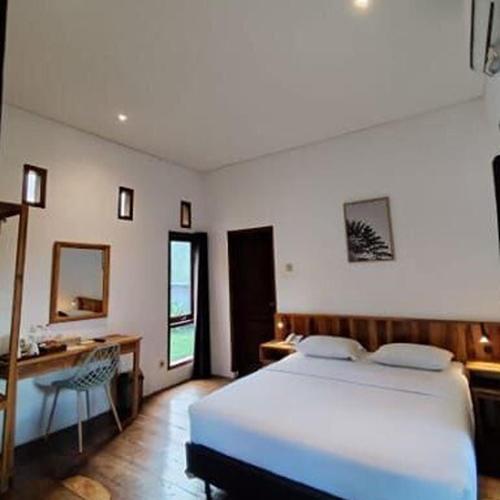a bedroom with a white bed and a desk and a chair at Negla Beach Villa in Godog