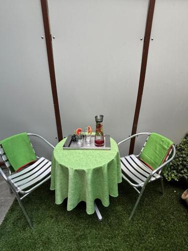 a table with two chairs and a vase on it at Caro’s Gartenwohnung in Vienna
