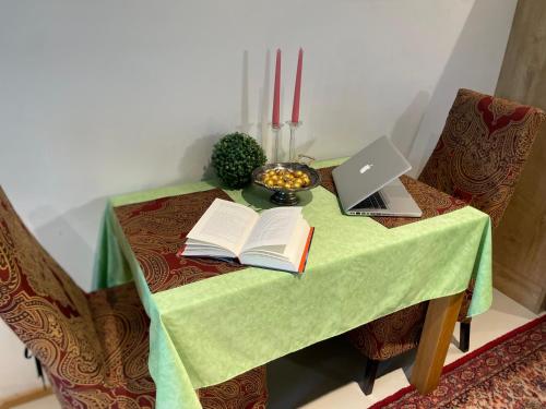 a table with a laptop and books on it at Caro’s Gartenwohnung in Vienna