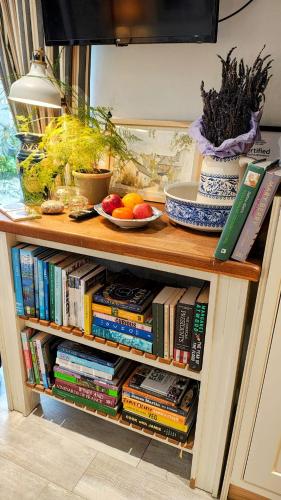 a book shelf with books and fruit on it at Ropewalk Cottage - A Little Treasure By The Coast in Portaferry