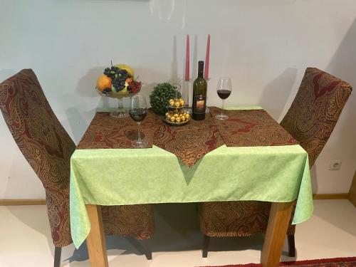 a table with a green table cloth and wine glasses at Caro’s Gartenwohnung in Vienna