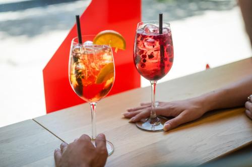 two people sitting at a table with two drinks at MEININGER Hotel Hamburg City Center in Hamburg
