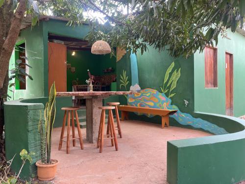 a room with a bed and a table and stools at Quarto para 6 a 900m da Vila do Capão in Vale do Capao